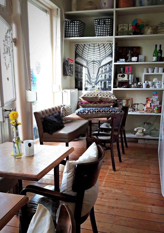 zuhause cafe interior caferoom with pillows on a table and a shelf full of living accessories