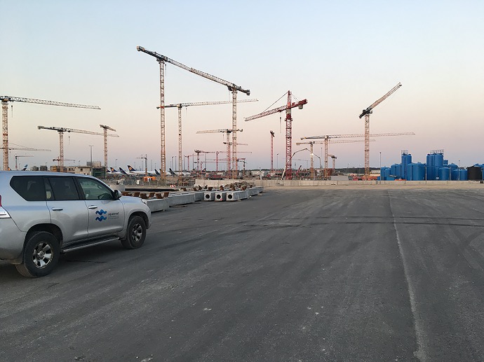 company car label aquasenat construction site on a large airport area with construction cranes in the background and a large company vehicle on the left side